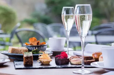 a table with two glasses of wine and food at The Swan At Hay in Hay-on-Wye