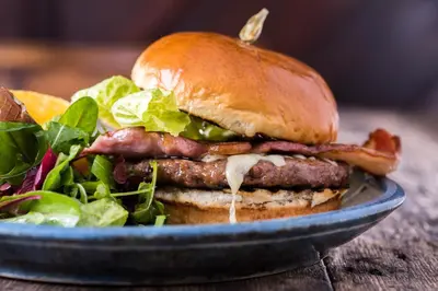 a sandwich on a blue plate with a salad at The Swan At Hay in Hay-on-Wye