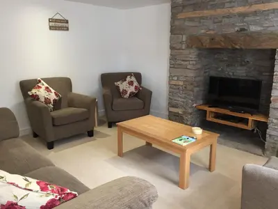 a living room with two chairs and a fireplace at March Cottage Brecon in Brecon