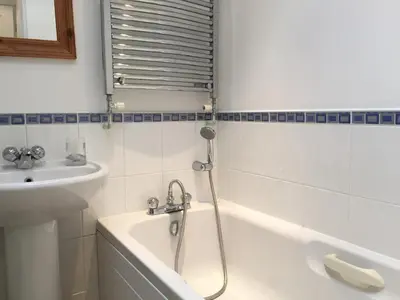 a bathroom with a bath tub and a sink at March Cottage Brecon in Brecon