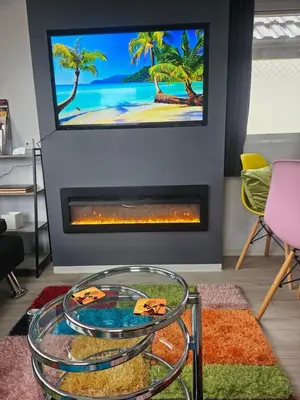 a living room with a fireplace with a tv above it at Ruth's Rest Country Retreat with private Hot Tub & Views of Open Countryside in Shrewsbury