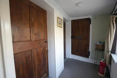 a hallway with a large wooden door in a house at Fitzwarine House Whittington in Whittington
