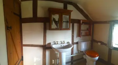 a bathroom with a sink and a toilet at Yew Tree Cottage in Leominster
