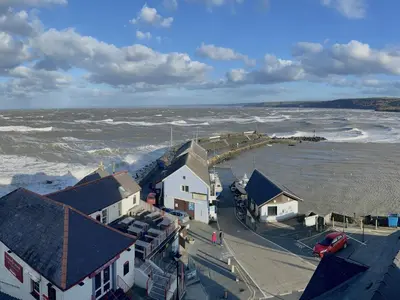 an aerial view of a beach with waves and houses at Seascape in New Quay