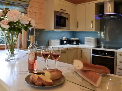 a kitchen with two glasses of wine and bread at Ty Pren in Dyffryn
