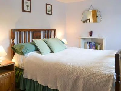 a bedroom with a large white bed with blue pillows at Upper Ffinnant in Aber-Brân