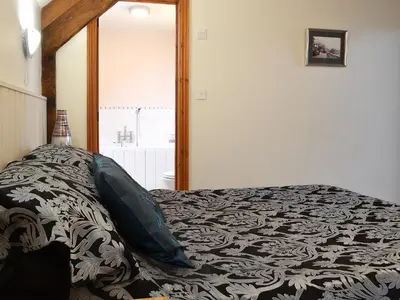a bedroom with a bed with a black and white blanket at Chalgrove in Aber-Brân