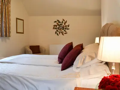 a bedroom with a white bed with purple pillows at Chalgrove in Aber-Brân