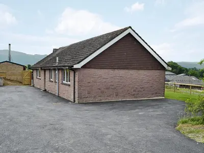 a large brick building with a parking lot at Dolview in Penybont