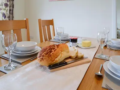 a table with a loaf of bread and wine glasses at Dolview in Penybont