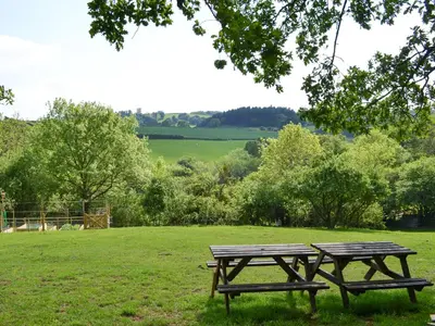 a picnic table and bench in a field at Burrills View in Horderley