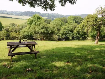 a picnic table in a field with wine glasses on it at Burrills View in Horderley