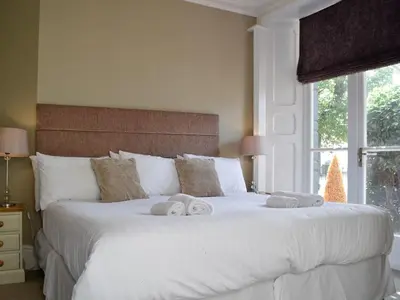 a bedroom with a white bed with towels on it at Llys yr Wylan in Aberystwyth