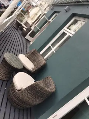 a balcony with wicker chairs on a building at Llys yr Onnen in Aberystwyth