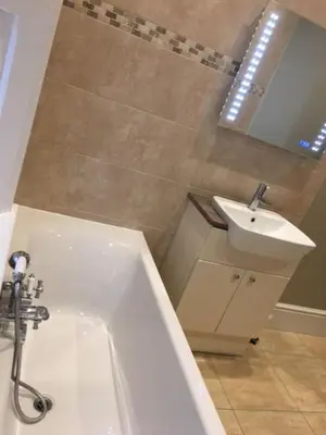 a bathroom with a white tub and a sink at Llys yr Onnen in Aberystwyth