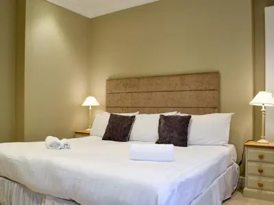 a bedroom with a large white bed with two lamps at Llys Celyn - Holly Farm in Aberystwyth