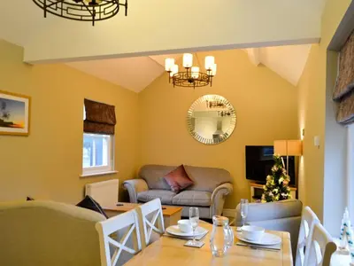a living room with a table and a couch at Llys Celyn - Holly Farm in Aberystwyth