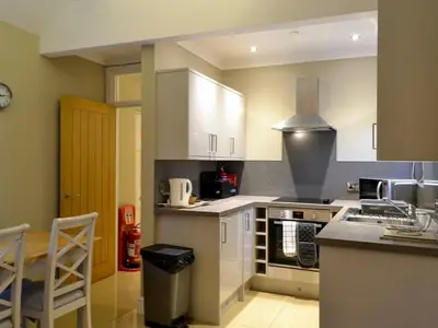 a kitchen with white cabinets and a stove top oven at Llys Celyn - Holly Farm in Aberystwyth