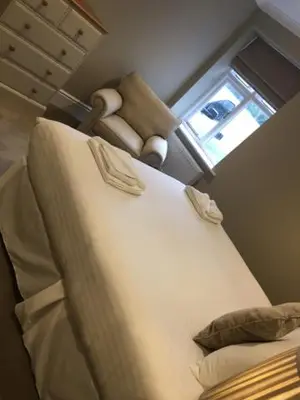 a bedroom with a bed and a chair and a window at Llys y Barnwr - Judge's Court in Aberystwyth