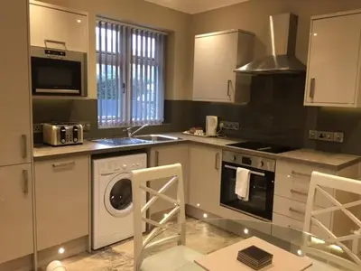 a kitchen with a washing machine and a washer at Llys y Barnwr - Judge's Court in Aberystwyth