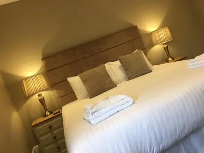 a bedroom with a bed with two towels on it at Llys y Barnwr - Judge's Court in Aberystwyth