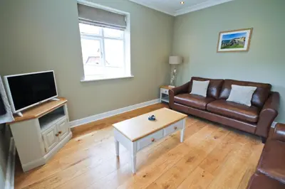 a living room with a couch and a coffee table at Llys y Dderwen - Oak Court in Aberystwyth