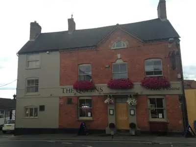 a red brick building with flowers on the front at The Queens in Ludlow