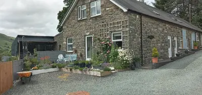 a stone house with plants on the side of it at Pant Glas Barn in Llanbrynmair