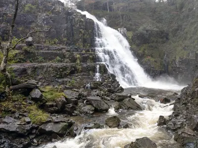 a waterfall on the side of a mountain at Pant Glas Barn in Llanbrynmair