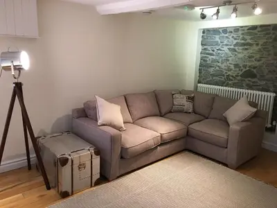 a living room with a couch and a camera at Riverside Suites Llangollen in Llangollen