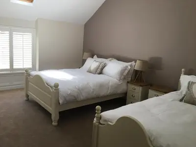 a bedroom with two beds and a window at Riverside Suites Llangollen in Llangollen