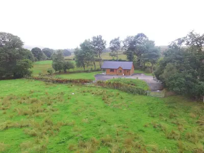 a house in the middle of a green field at LLanddewi Retreat in Llanddewi Ystradenny