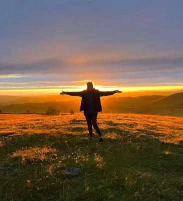 a person standing on top of a field with their arms out at Upper Gilwern Quarry Hut in Llandrindod Wells