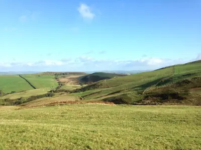 a grassy hillside with a view of a field at Upper Gilwern Quarry Hut in Llandrindod Wells
