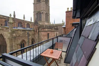 a balcony with a pink table and a church at Church Inn in Ludlow