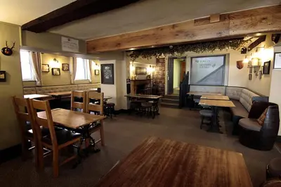 a restaurant with tables and chairs and a bar at Church Inn in Ludlow