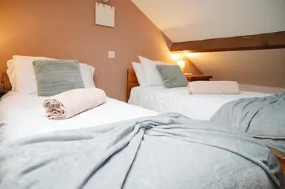 two beds with blankets on them in a room at Vale Farm Cottages in Brecon