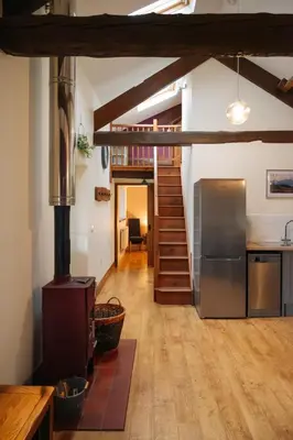 a kitchen with a refrigerator and a staircase at Vale Farm Cottages in Brecon