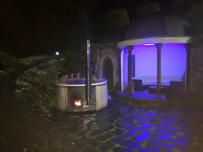 a gazebo with a fireplace in a yard at night at Bryn Melyn Farm Cottages in Bala