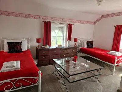 a bedroom with two beds and a glass table at Ty Llew in Llandysilio