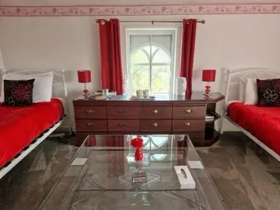 a living room with two beds and a glass table at Ty Llew in Llandysilio