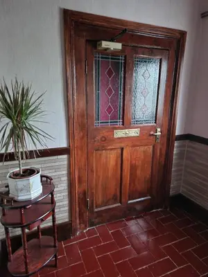 a wooden door with a potted plant on a table at Ty Llew in Llandysilio