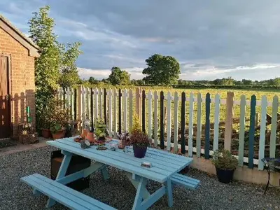 a blue picnic table in front of a fence at Ty Llew in Llandysilio
