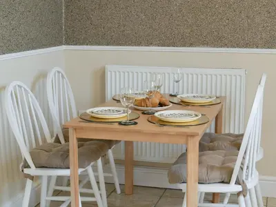 a wooden table with plates and wine glasses on it at Yr Hen Fanc in Trawsfynydd