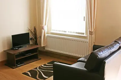 a living room with a couch and a television at The Gremlin Lodge in Brecon