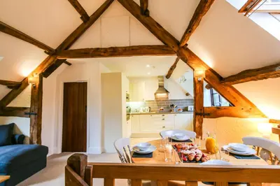 a kitchen and dining room with a table and chairs at Lake Cottages at Cwm Chwefru in Llanafan-fawr