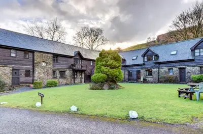 a large building with a park in front of it at Lake Cottages at Cwm Chwefru in Llanafan-fawr
