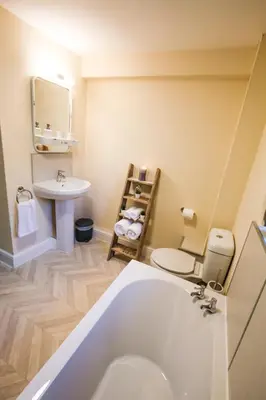 a bathroom with a white tub and a sink at Lake Cottages at Cwm Chwefru in Llanafan-fawr