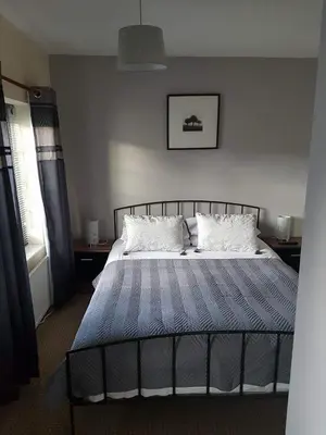 a bedroom with a bed with a blue and white comforter at The Lamb and Flag Inn in Rhayader