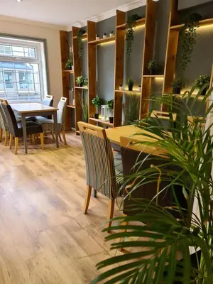 a dining room with a table and chairs and a plant at The Lamb and Flag Inn in Rhayader
